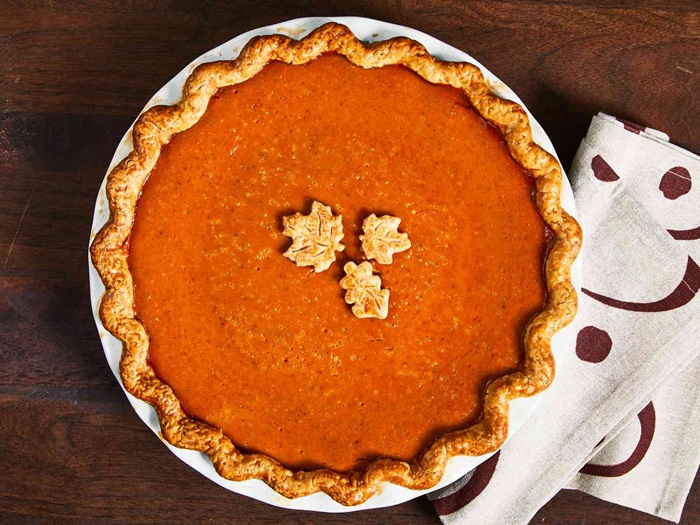 A pumpkin pie adorned with leaves made of pie crust.